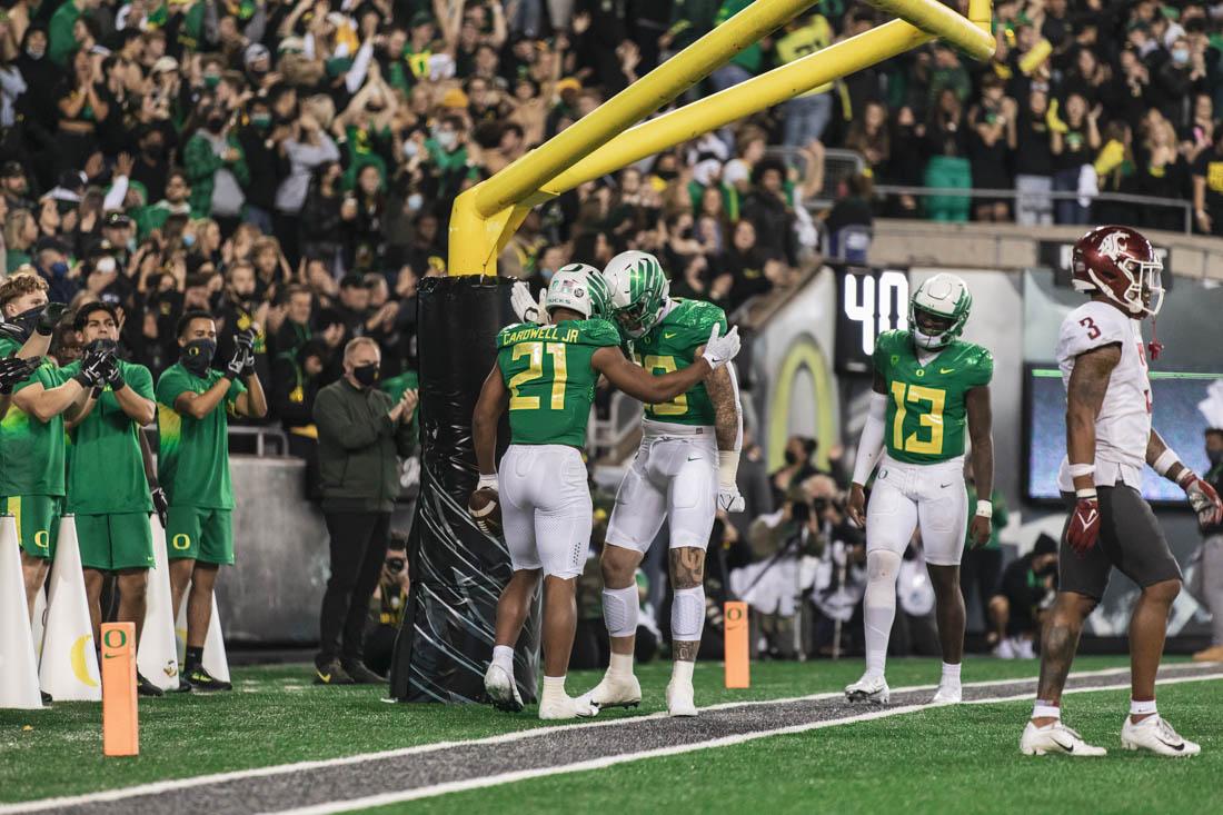 Ducks running back Byron Cardwell (21) celebrates with a teammate after scoring a touchdown. Ducks football take on the Washington State Cougars at Autzen Stadium in Eugene, Ore., on Nov. 13, 2021. (Maddie Stellingwerf)