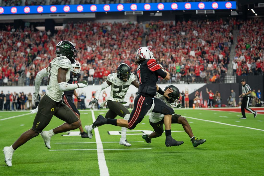 Cameron Rising (7), after running past the Oregon defensive line, stiff arms a Ducks playere coming in for a tackle. The Oregon Ducks take on the Utah Utes at Allegiant Stadium in Las Vegas, Nev., on December 3, 2021. (Serei Hendrie/Emerald)