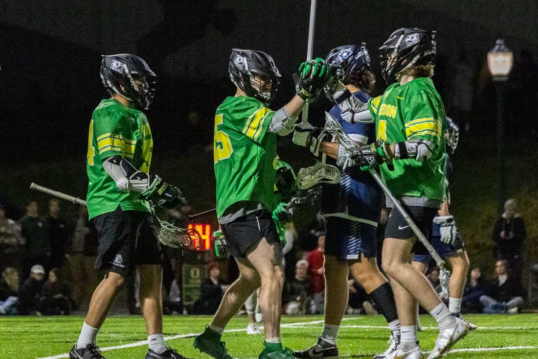 The Ducks offense celebrates after scoring a goal. The Oregon Ducks Men&#8217;s Lacrosse team takes on Reno, on Feb. 19 on Rec Field 2. (Molly McPherson/Emerald)