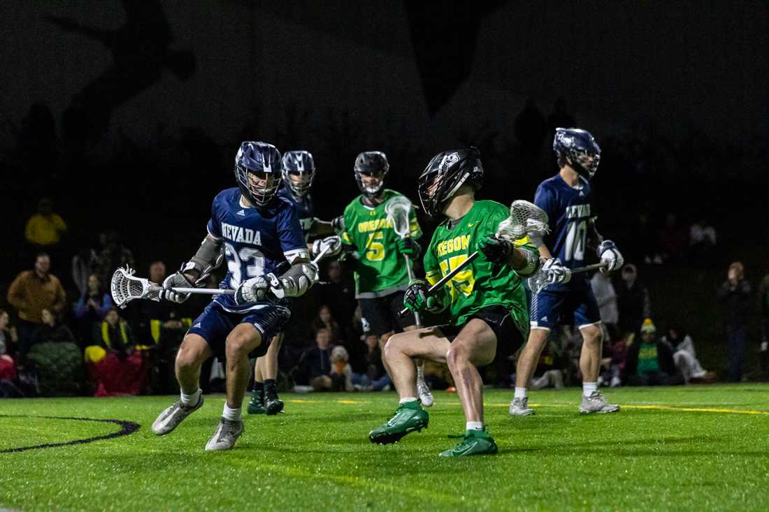 Frankie Cortes (55) dodges to try and shake off his defender. The Oregon Ducks Men&#8217;s Lacrosse team takes on Reno, on Feb. 19 on Rec Field 2. (Molly McPherson/Emerald)