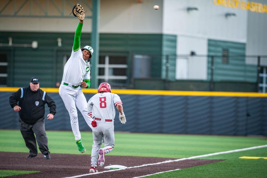 First-baseman Jacob Walsh (25) jumps up and just misses the ball as his opponent reaches the base. Oregon Baseball takes on the Washington State Cougars at PK Field in Eugene, Ore. on April 22, 2022. (Mary Grosswendt/Emerald)