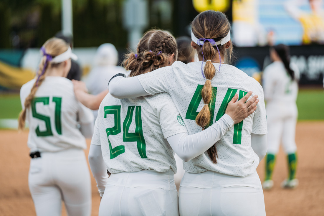 Players, Hannah Delgado (left) and Tehya Bird (right), embrace as the Ducks team watches season highlights play on the jumbotron. The Oregon Ducks Softball team faces the Oregon State Beavers, on May 1st, 2022, at Jane Sanders Stadium. (Serei Hendrie/Emerald)