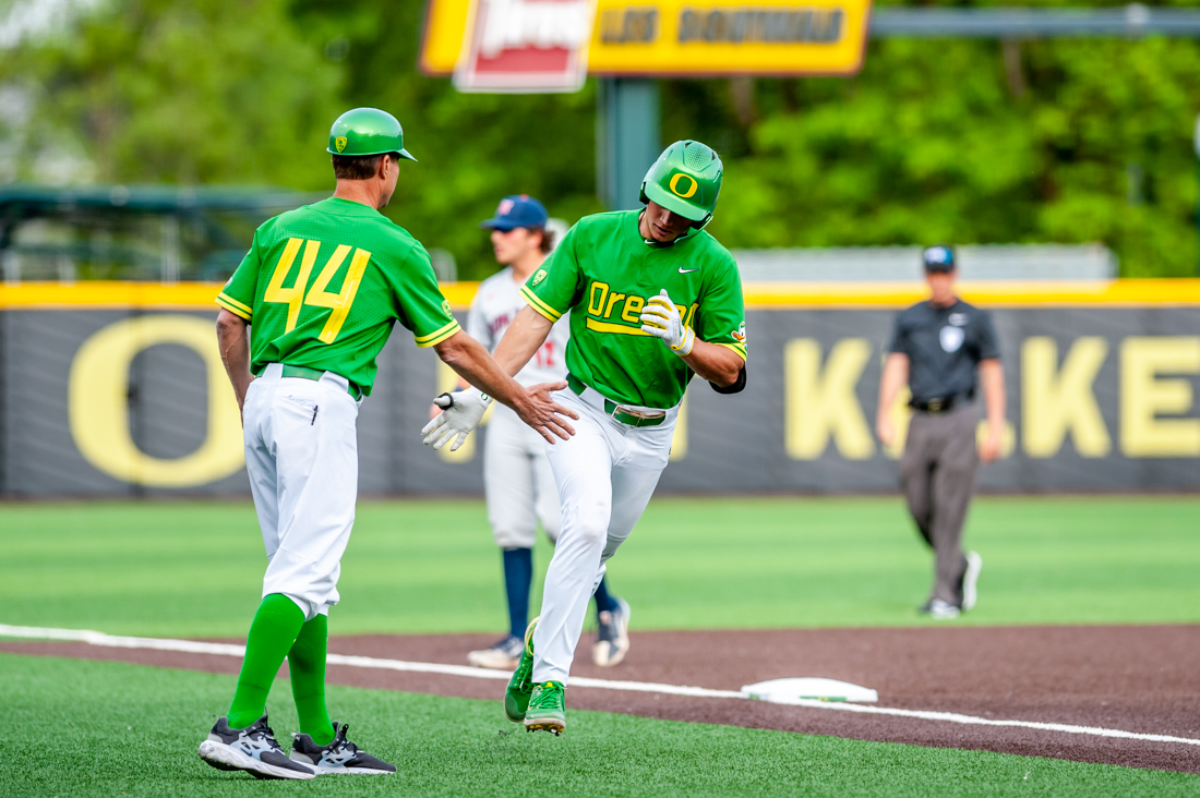 Josh Kasevich (04) gets a high five while rounding third after hitting a homerun. The Oregon Baseball team takes on Gonzaga on May 17th, 2022, at PK Park. (Molly McPherson/Emerald)