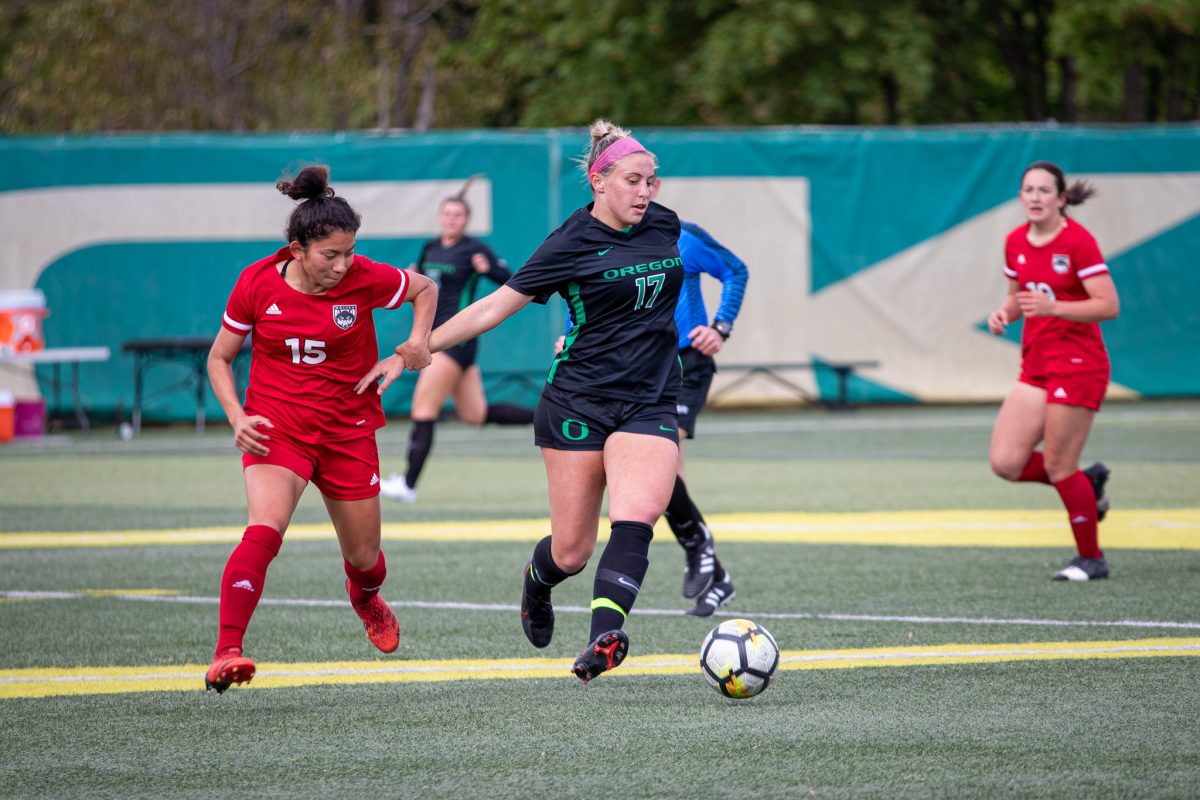 A Western Oregon defender holds onto the wrist of Zoe Hasenauer as she tries to keep her away from the ball.&#160;The Oregon Ducks Soccer Team Host Western Oregon at Pape Field on May 7, 2022. (Jonathan Suni, Emerald)