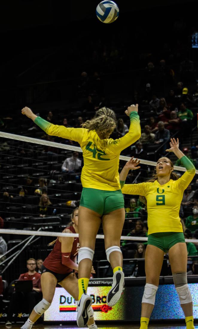 Karson Bacon (42) jumps up to spike the ball after a set from Hannah Pukis (9). Oregon women&#8217;s volleyball takes on Washington State at Matthew Knight Arena in Eugene, Ore. on Nov. 6, 2022. (Mary Grosswendt/Emerald)