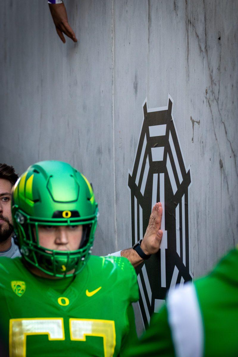 An Oregon Duck coach puts his hand on a tribute for Spencer Webb on the way out of the tunnel after halftime.&#160;The Oregon Ducks travel up to Corvallis to face their in-state rival the Oregon State Beavers on November 26th, 2022, for their last game of the regular season.&#160;(Jonathan Suni, Emerald)