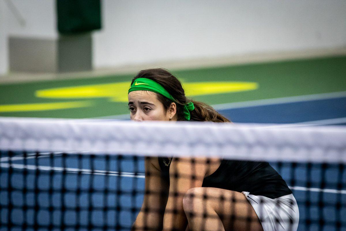 Uxia Moral peaks over the net while her teammate prepares to serve.&#160;The Oregon Women's Tennis team hosts Portland State at the Student Tennis Center in Eugene, Ore., on January 20th. (Jonathan Suni, Emerald)