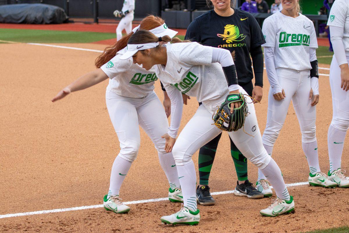 Tehya Bird (44) and teammate Vallery Wong (99) hype each other up as the team is being announced.&#160;The Oregon Ducks Softball Team hosts Washington on April 22nd,2022, at Jane Sanders Stadium. (Jonathan Suni, Emerald)