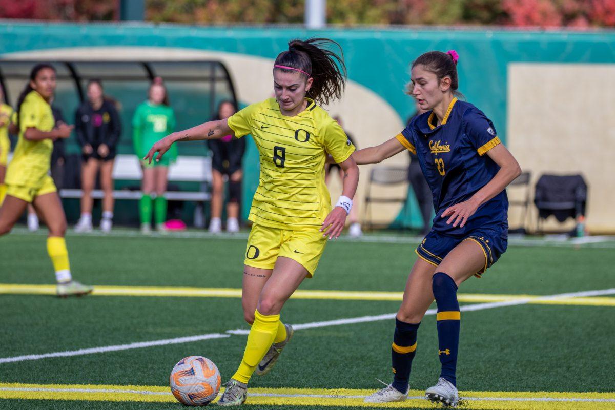 A Golden Bear defender grabs ahold of Lexi Romero (8) as she tries to dribble away.&#160;The Ducks host the Golden Bears at Papa Field on October 23rd, 2022. (Jonathan Suni, Emerald)