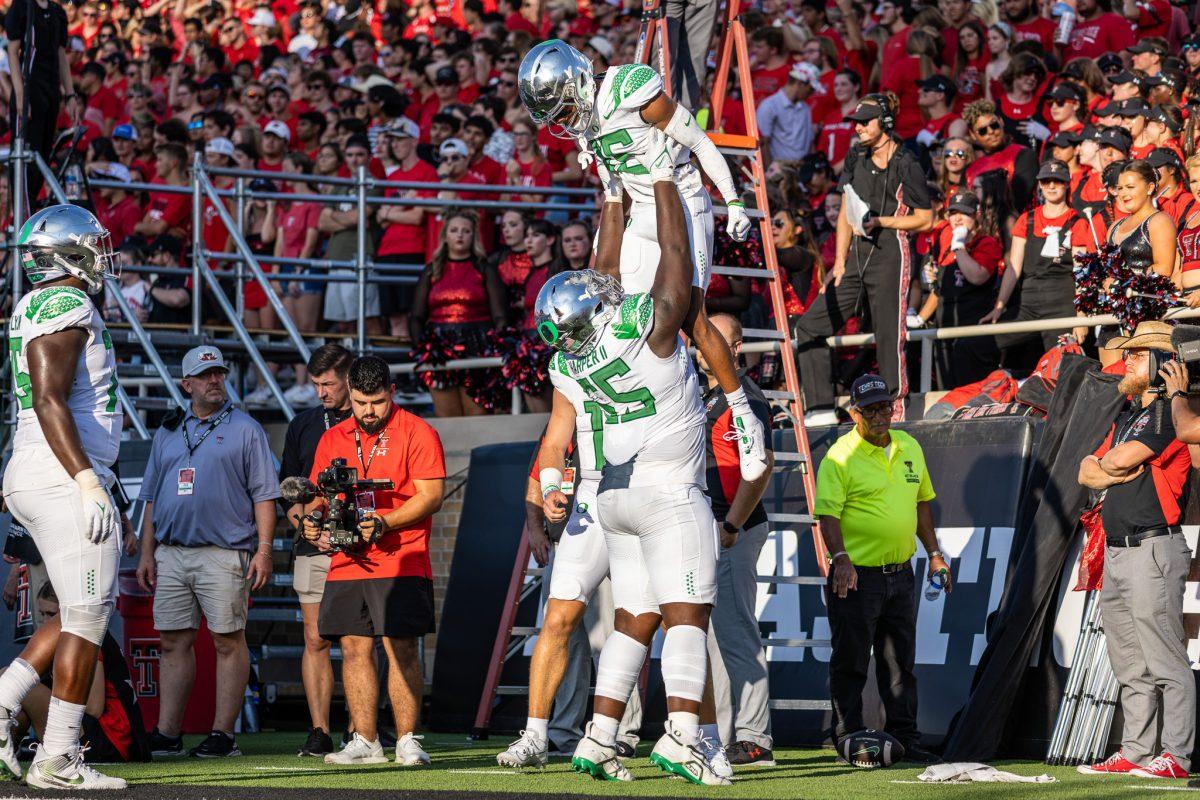 Tez Johnson (15) celebrates with Oregon offensive lineman Marcus Harper II (55) after a big offensive drive.&#160;The Oregon Ducks battle in a close fight to ultimately beat the Texas Tech Red Raiders in their home opener at Jones AT&amp;T Stadium in Lubbock, Texas, on Sept. 9, 2023. (Jonathan Suni/Emerald)