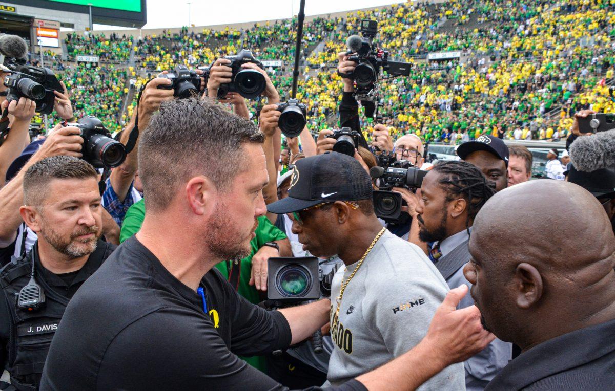 <p>Head coaches Dan Lanning and Deion Sanders meet at the 50-yardline postgame. The University of Oregon Ducks Football team defeat the University of Colorado Buffaloes 42-6 at Autzen Stadium in Eugene, Oregon, on September 23, 2023. (Kai Kanzer/Emerald)</p>