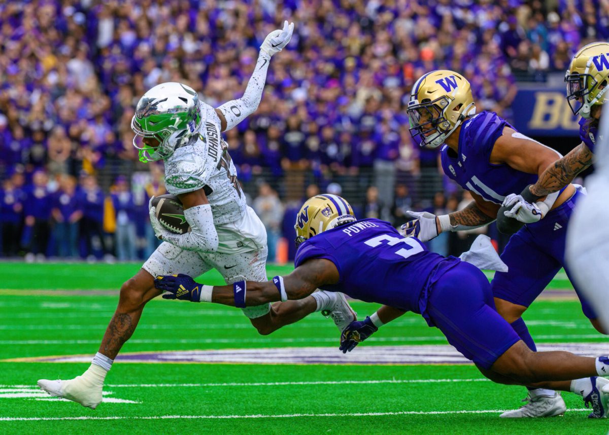 Tez Johnson (15) evades a group of defenders. The University of Oregon Ducks Football team were defeated by the University of Washington Huskies in an away match at Husky Stadium in Seattle, Washington, on October 14, 2023. (Eric Becker/Emerald)