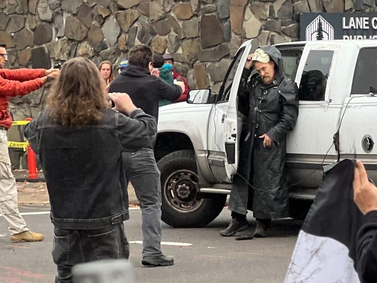 The man exiting the truck is the suspect who fired into the crowd with a "splatter ball gun." Two other people are holding handguns aimed at the man. (Proctor/Emerald)