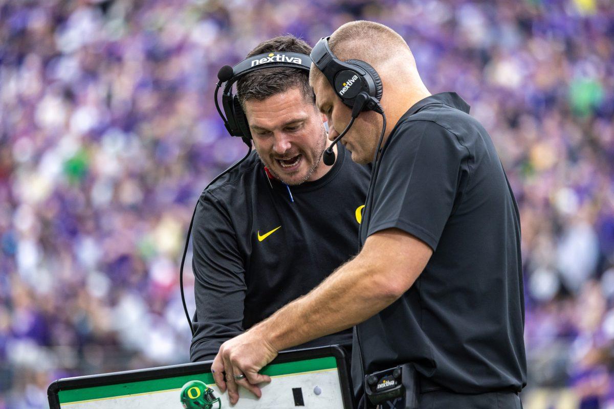 <p>Coach Dan Lanning and defensive coordinator Tosh Lupoi talk over plays as they look to pull of a pivotal defensive stand at the one yard line. The University of Oregon Ducks Football team were defeated by the University of Washington Huskies in an away match at Husky Stadium in Seattle, Washington, on October 14, 2023. (Jonathan Suni/Emerald)</p>