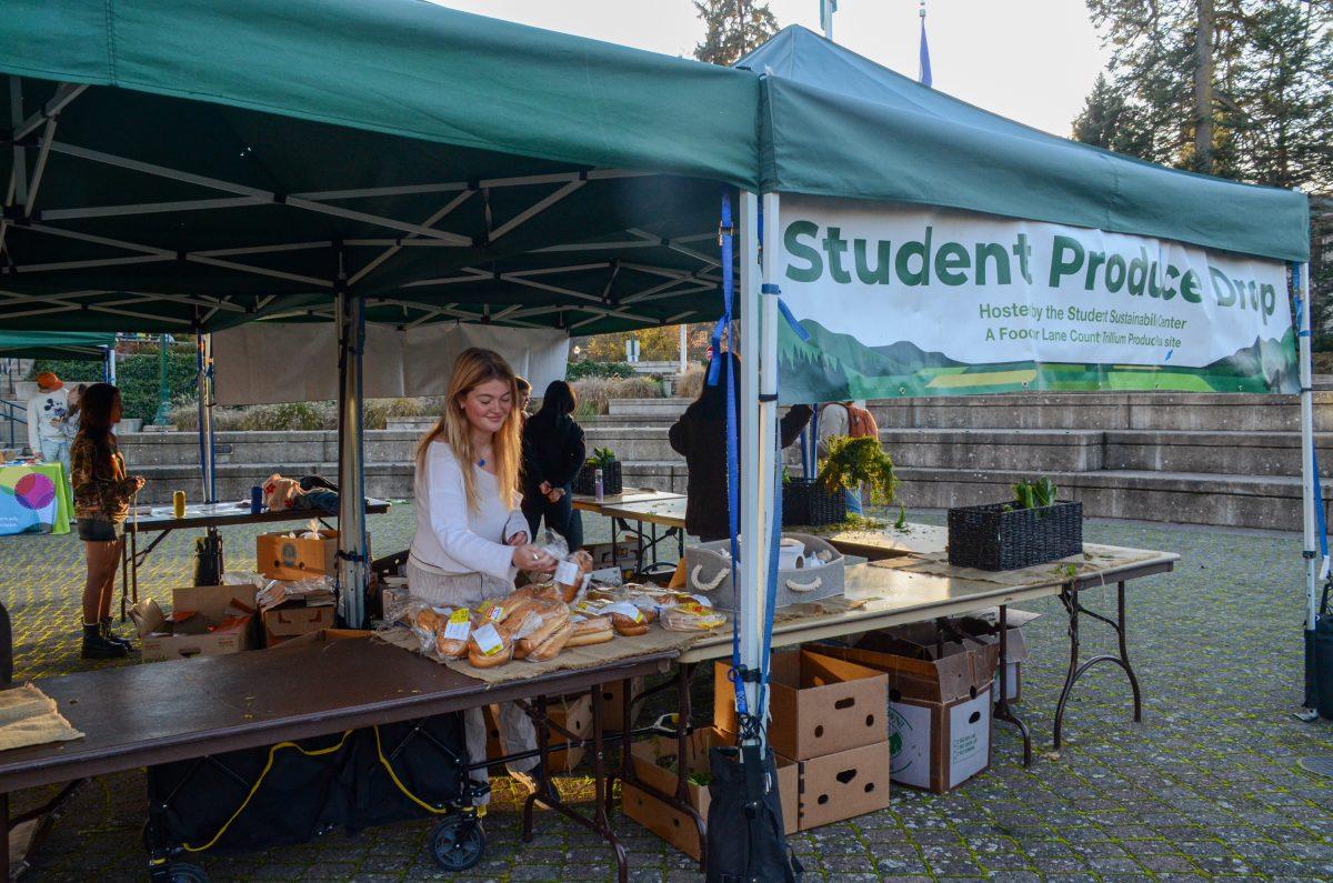 Riley Cudahy organizes food at the Student Produce Drop. The produce drop happens every Tuesday from 3:00&#8211;5:00 p.m. Free for students. (Kai Kanzer/Emerald)