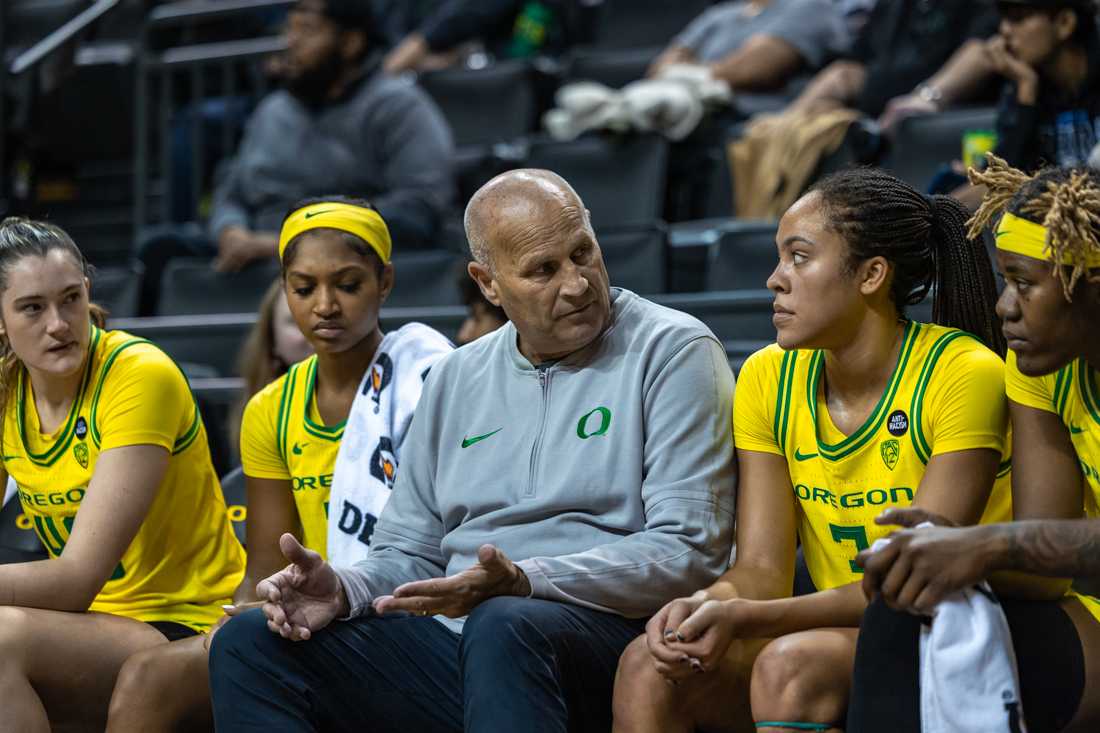 Kelly Graves sits between his starters on the bench and talks with them about how the game is going. The Oregon Ducks women&#8217;s basketball team takes on the Santa Clara Broncos on Nov. 18, 2023 in Eugene, Ore. (Molly McPherson/Emerald)