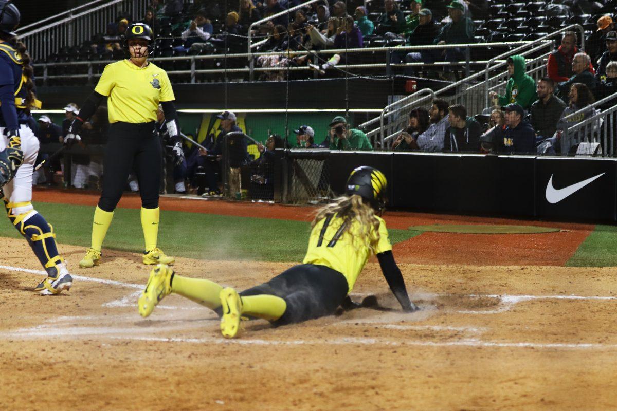 Regan Legg (17) slides into home plate. The Oregon Softball team defeats California 4-3 in their second game against them in a doubleheader on March 8, 2024, in Eugene, Ore., at Jane Sanders Stadium. (Alyssa Garcia/Emerald)