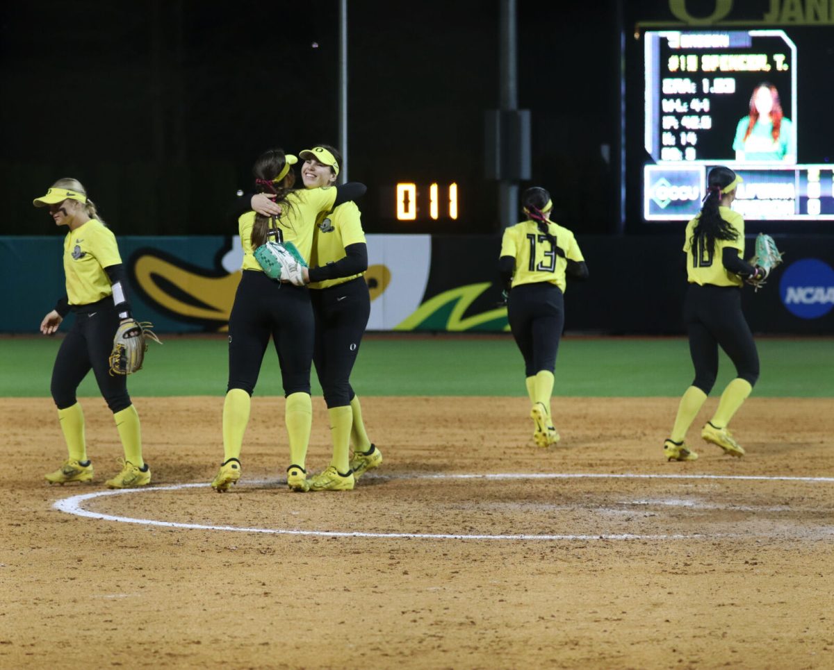 Katie Flannery (6) gives Taylour Spencer (19) a hug before the start of the inning. The Oregon Softball team defeats California 4-3 in their second game against them in a doubleheader on March 8, 2024, in Eugene, Ore., at Jane Sanders Stadium. (Alyssa Garcia/Emerald)