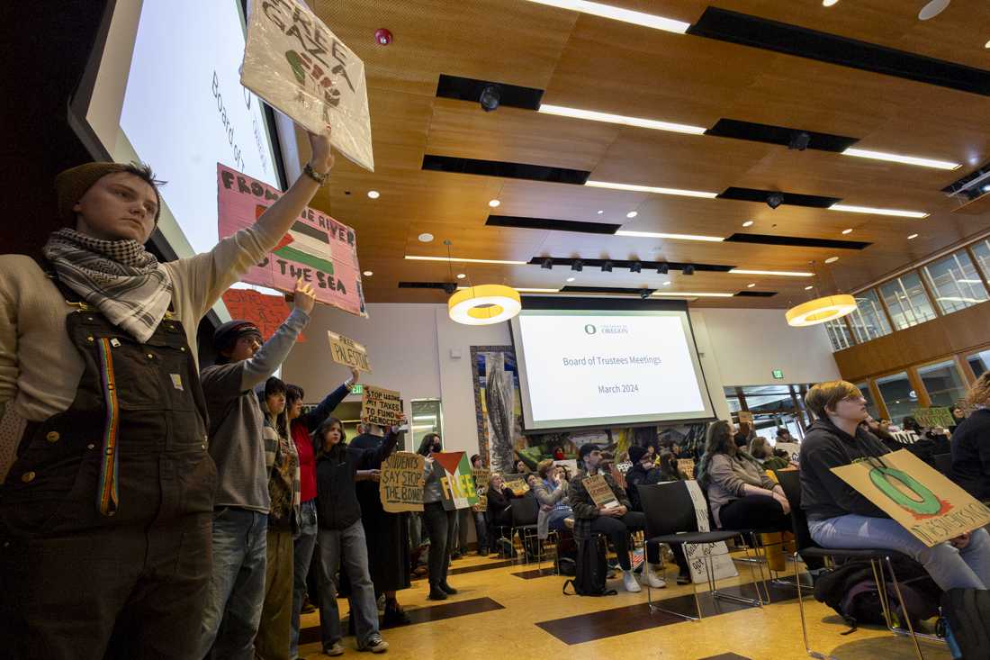 Attendees hold up signs in support of Gaza at the meeting on March 12, 2024. People gathered outside of the Ford Alumni Center for a rally before the University of Oregon Board of Trustees meeting, where some spoke during the public comments section alongside other students and community members, with topics ranging from proposed "Boycott, Divest, Sanction" strategies, to Jewish students feeling unsafe due to protests and demonstrations on campus. (Alex Hernandez/Emerald)