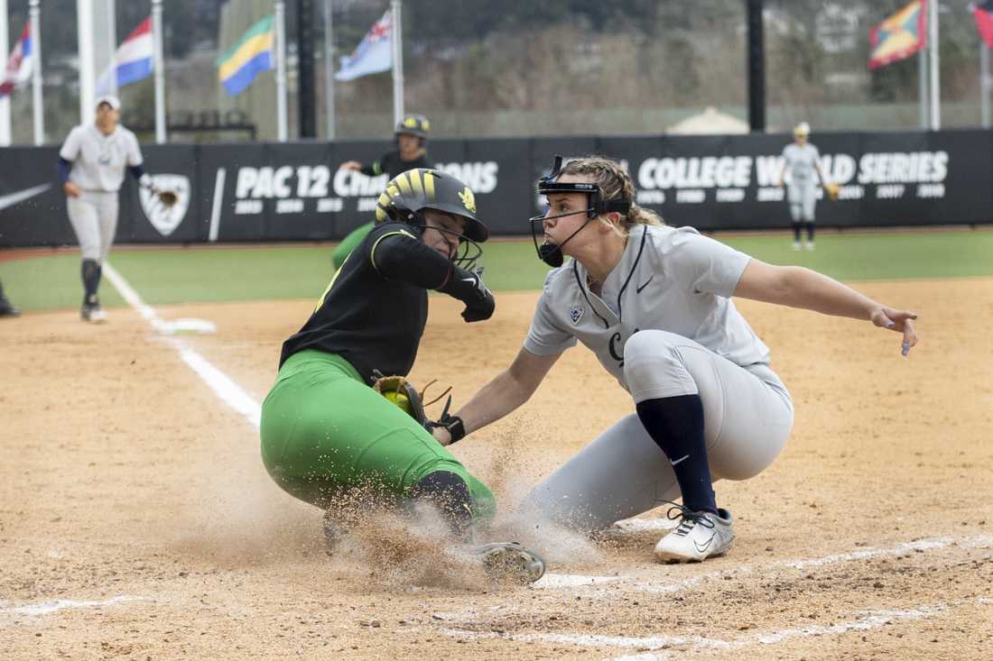 Oregon's Hanna Delgado (24) slides into home plate as UC Berkeley's Randi Roelling (12) looks to tag her. The Oregon women's softball team took a 5-2 win as they faced off against the University of California, Berkeley's Golden Bears at Jane Saunders Stadium on March 9, 2024. (Alex Hernandez/Emerald)