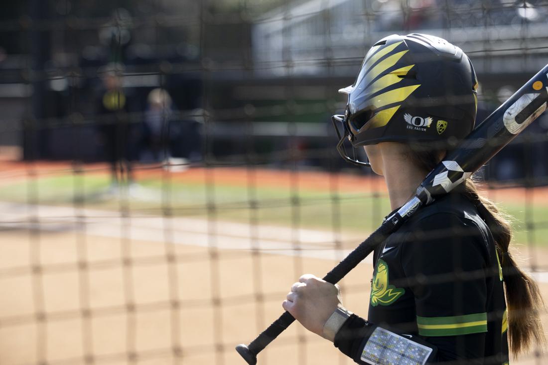 A player stands near the dugout with her bat. The Oregon women's softball team took a 5-2 win as they faced off against the University of California, Berkeley's Golden Bears at Jane Saunders Stadium on March 9, 2024. (Alex Hernandez/Emerald)