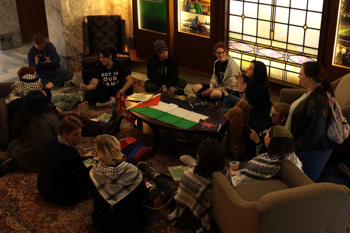 SJP members stage a sit-in outside of President Scholz's office, wrists tied together with rope. (Colleen Bogdan/Emerald)