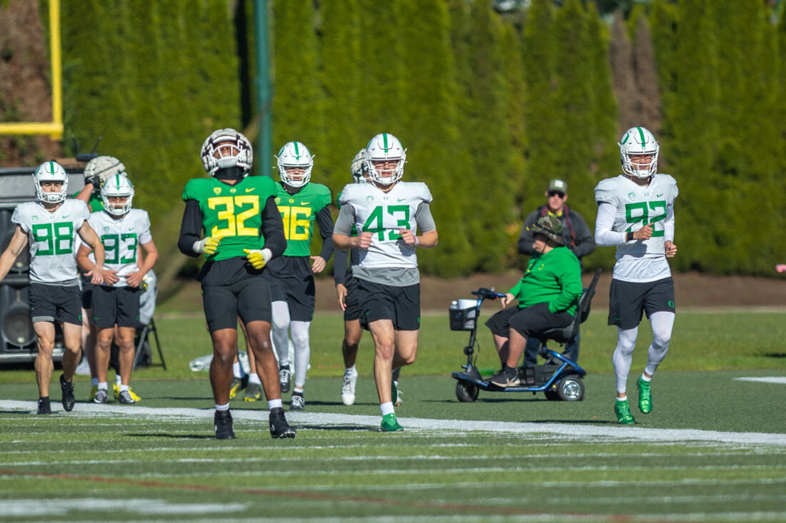 Players from all different positions run down the field during warm-ups. The Oregon Ducks football team takes the field at the Hatfield-Dowlin Complex on a cool Thursday morning for a practice in Eugene, Ore on April 18, 2023. (Molly McPherson/Emerald)