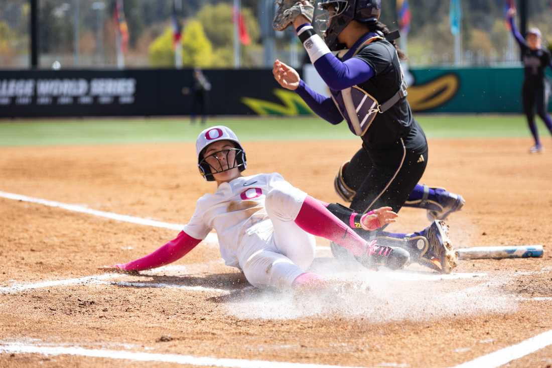 Kai Luschar (22) slid into home base but was thrown out at the plate. The University of Oregon Softball team defeated University of Washington 6-4 in a Pac-12 series at Jane Sanders Stadium in Eugene, Ore., on April 7, 2024. (Kemper Flood/Emerald)