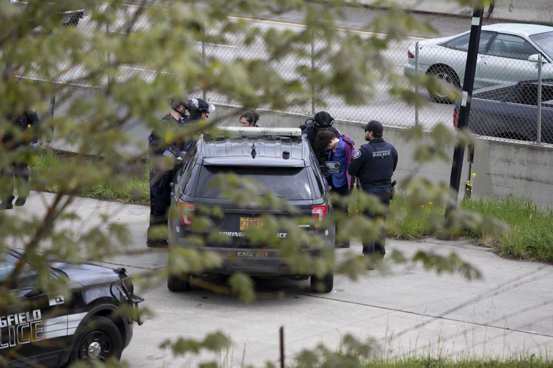 Police take an individual into custody after a protest on the I-5 on April 15, 2024. Protesters gathered on the Harlow Rd. bridge and I-5 below, blocking traffic, "as part of a global economic blockage to free Palestine," according to an Instagram post by the Springfield-Eugene Anti-Imperialist Coalition (@anti.imperialist.coalition). The demonstration was organized in conjunction with other actions across the world as part of the "A15 Economic Blockades for a Free Palestine." (Alex Hernandez/Emerald)