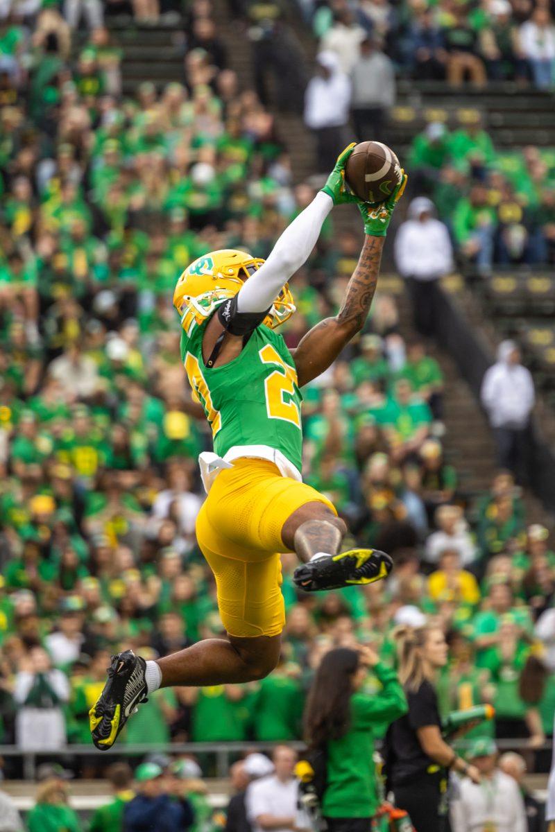 Daylen Austin (27) leaps in the air to catch the ball during pre-game warmups. The Oregon Ducks football team takes on the Washington State Cougars on Oct. 21, 2023, in Eugene, Ore. (Molly McPherson/Emerald)