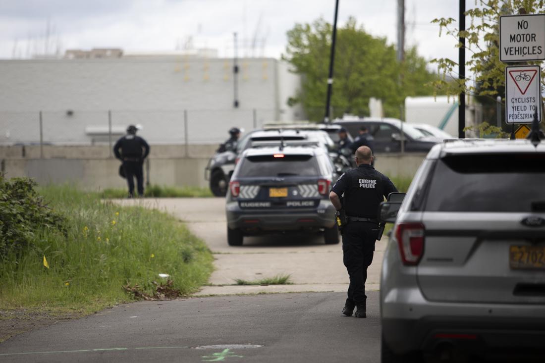 A police officer stands back and watches as police take people into custody after a protest on the I-5 on April 15, 2024. Protesters gathered on the Harlow Rd. bridge and I-5 below, blocking traffic, "as part of a global economic blockage to free Palestine," according to an Instagram post by the Springfield-Eugene Anti-Imperialist Coalition (@anti.imperialist.coalition). The demonstration was organized in conjunction with other actions across the world as part of the "A15 Economic Blockades for a Free Palestine." (Alex Hernandez/Emerald)