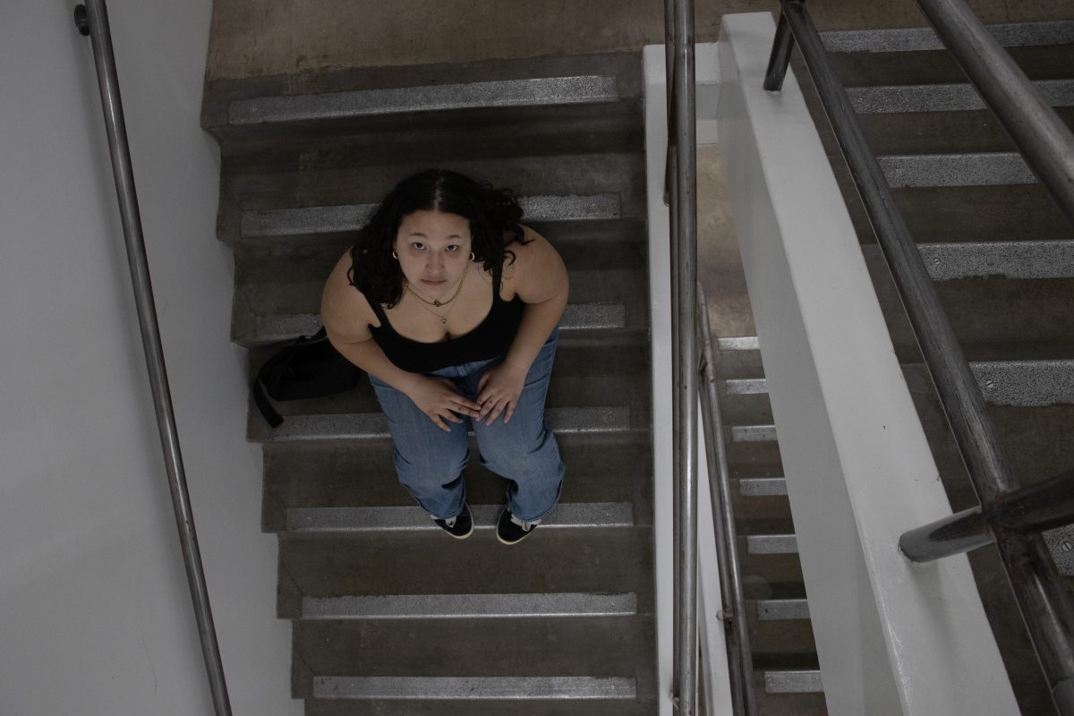 Hamilton dorm resident, Mckenzee Manlupig, sitting in the Collier Wing stairwell. As a sophomore transfer student from The University of Hawaii at Manoa, Manlupig says &#8220;I think not having an elevator is really inaccessible, especially when you live on a higher floor.&#8221;