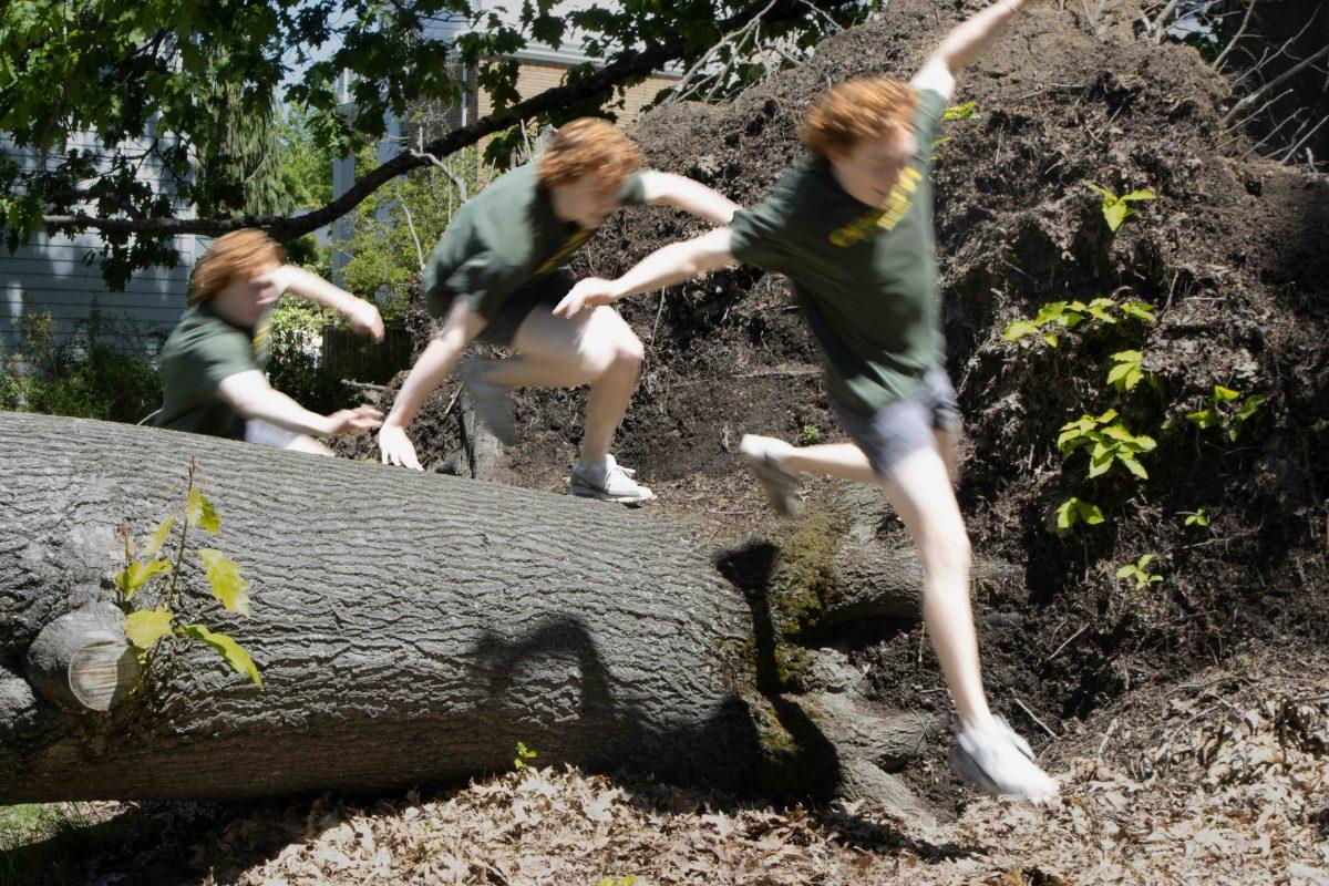 Jack Feist vaults over a tree.