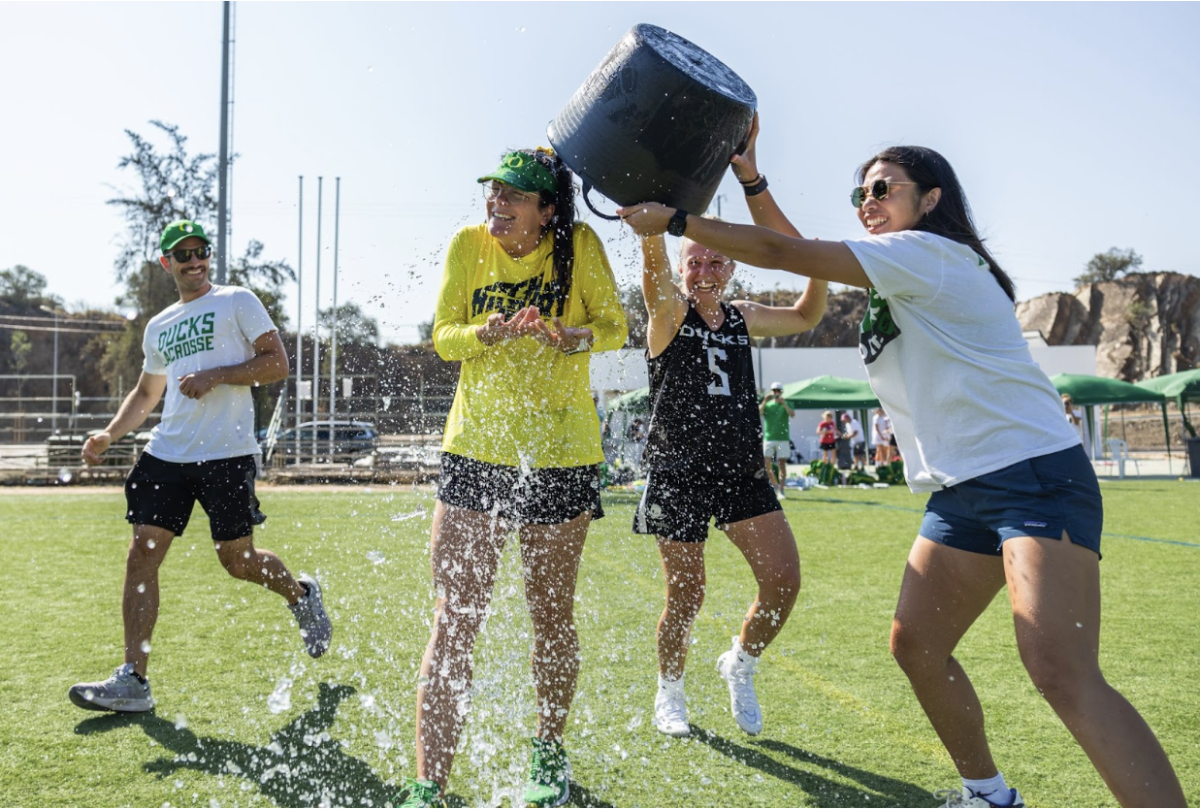 Oregon Women&#8217;s Lacrosse players and staff shower their new head coach, Jessica Drummond, in water after the Ducks defeat Team England Women&#8217;s Lacrosse 8-7. This is Drummond&#8217;s first win with UO and the team&#8217;s final game of the weekend series played in Monte Gordo, Portugal, from July 1-2, 2023.