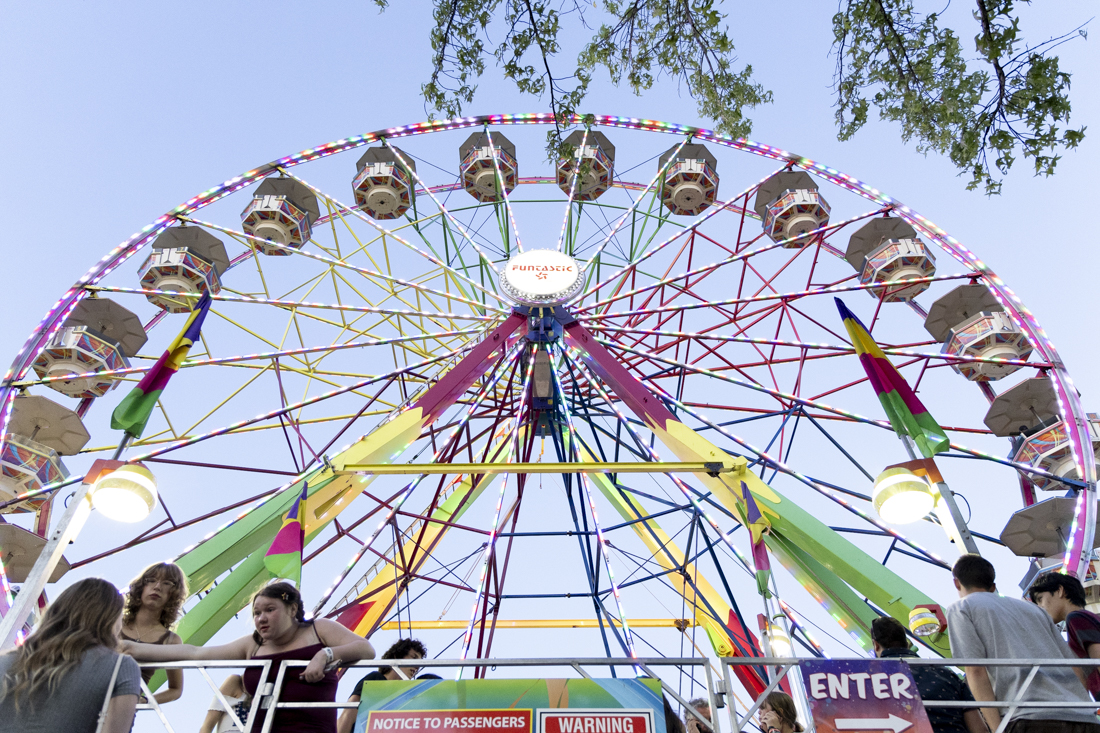 People speak to each other while waiting in line for the Ferris wheel at the fair on July 25, 2024. The 2024 Lane County Fair took place from July 24-28, featuring concerts, rides, vendors and more. (Alex Hernandez/Emerald)