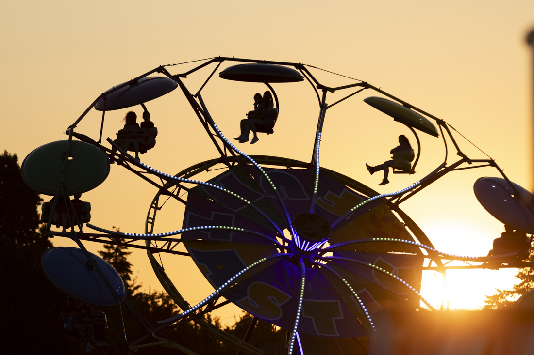 The sun sets on the fairgrounds as rides, games and more continue on July 25, 2024. The 2024 Lane County Fair took place from July 24-28, featuring concerts, rides, vendors and more. (Alex Hernandez/Emerald)