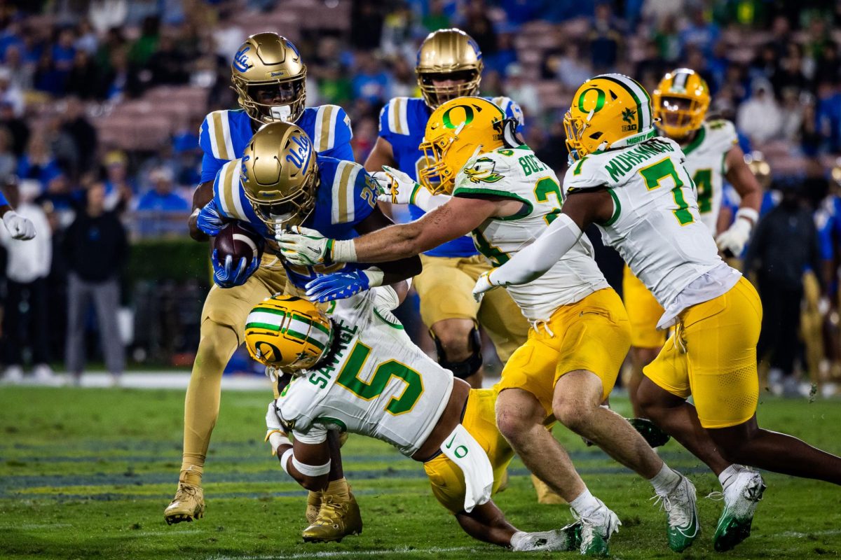 The Oregon defense swarms the UCLA ball carrier as the Ducks continue to show dominance on the defensive side of the ball. The Oregon Ducks take on the UCLA Bruins in its first Big Ten Conference game in the Rose Bowl in Pasadena, CA on Sept. 28, 2024. (Jonathan Suni/Emerald)