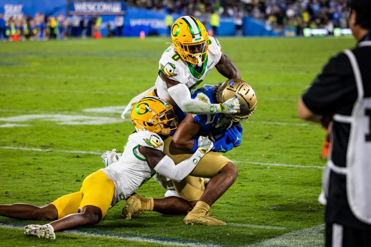 Nikko Reed (9) and Tysheem Johnson (0) take down a UCLA receiver to stop the first down attempt. The Oregon Ducks take on the UCLA Bruins in its first Big Ten Conference game in the Rose Bowl in Pasadena, CA on Sept. 28, 2024. (Jonathan Suni/Emerald)