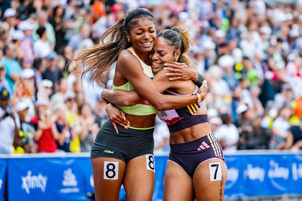 Veteren track star Gabby Thomas (8) embraces 
McKenzie Long (7) who won a national title on the same track weeks prior with Ole Miss. Long lost her mother the week of NCAA National Championships and just secured a chance to fight for gold in Paris. The most elite athletes in the country meet at Hayward Field for the 2024 Summer Olympic Trials in Eugene, Ore. on June 22, 2024. (Jonathan Suni/Emerald)