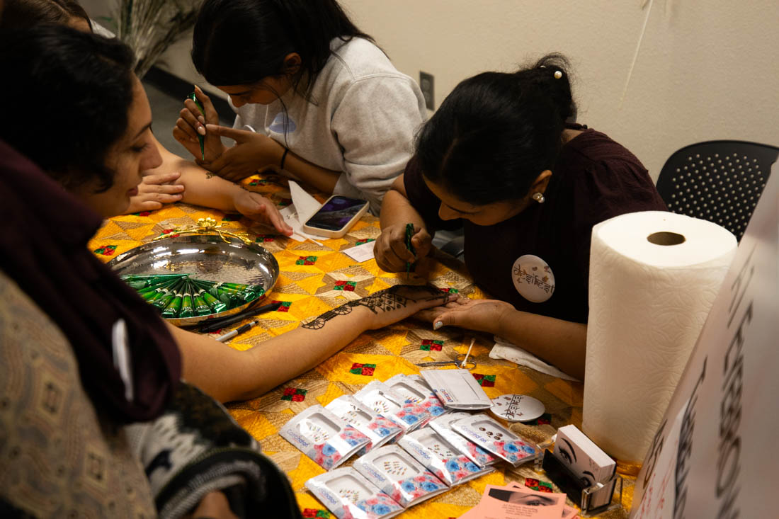 A woman gets henna applied to her hand. Desi Fest, at Lane Community College, celebrated South Asian culture with performances, food, and activities on Oct. 5, 2024. (Mason Cruz/Emerald)