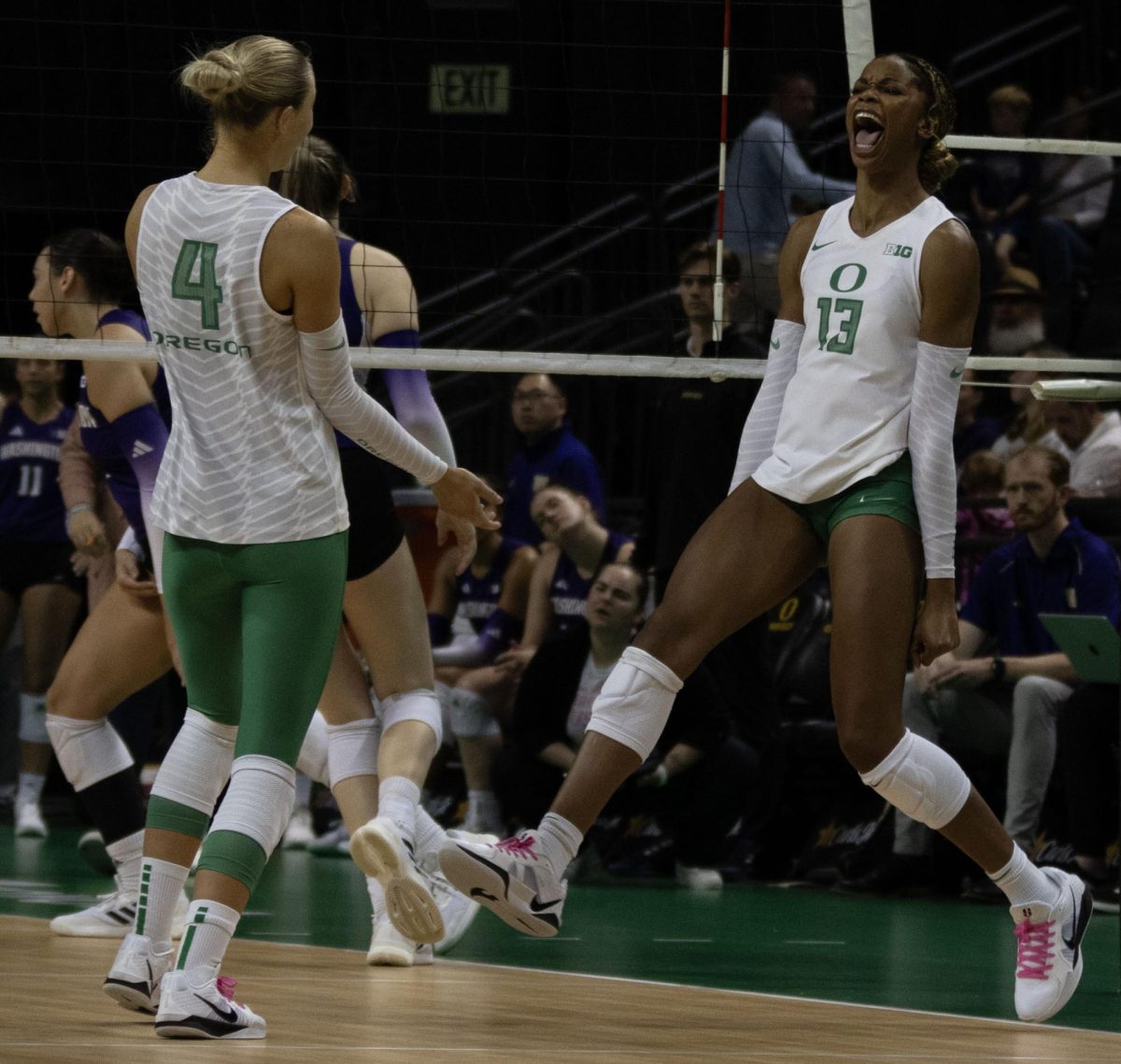 Oregon middle blocker Onye Ofoegbu (13) celebrates with defensive specialist Daley McClellan (4) after a successful spike onto the Washington floor. The University of Oregon Ducks fought tooth and nail for a 3-2 win over the University of Washington Huskies Sunday. Now 13-2 in the season, the Ducks next play the University of Wisconsin Badgers Oct. 18. (Miles Cull/Emerald)