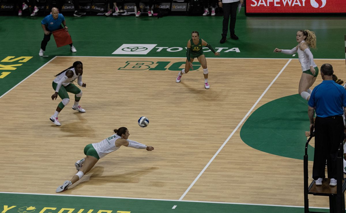 Oregon outside hitter Sophie Gregoire (6) sprawls for the ball. The University of Oregon Ducks fought tooth and nail for a 3-2 win over the University of Washington Huskies Sunday. Now 13-2 in the season, the Ducks next play the University of Wisconsin Badgers Oct. 18. (Miles Cull/Emerald)