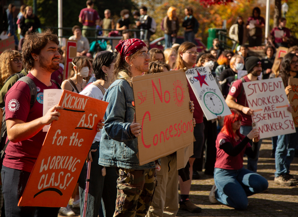 Members and supporters of the union proudly holding up their signs. On Oct. 25, 2024 The University of Oregon Student Workers Union rallied outside the Erb Memorial Union to show that the university is “failing on fundamental principles.” (Roshni Ram/Emerald)