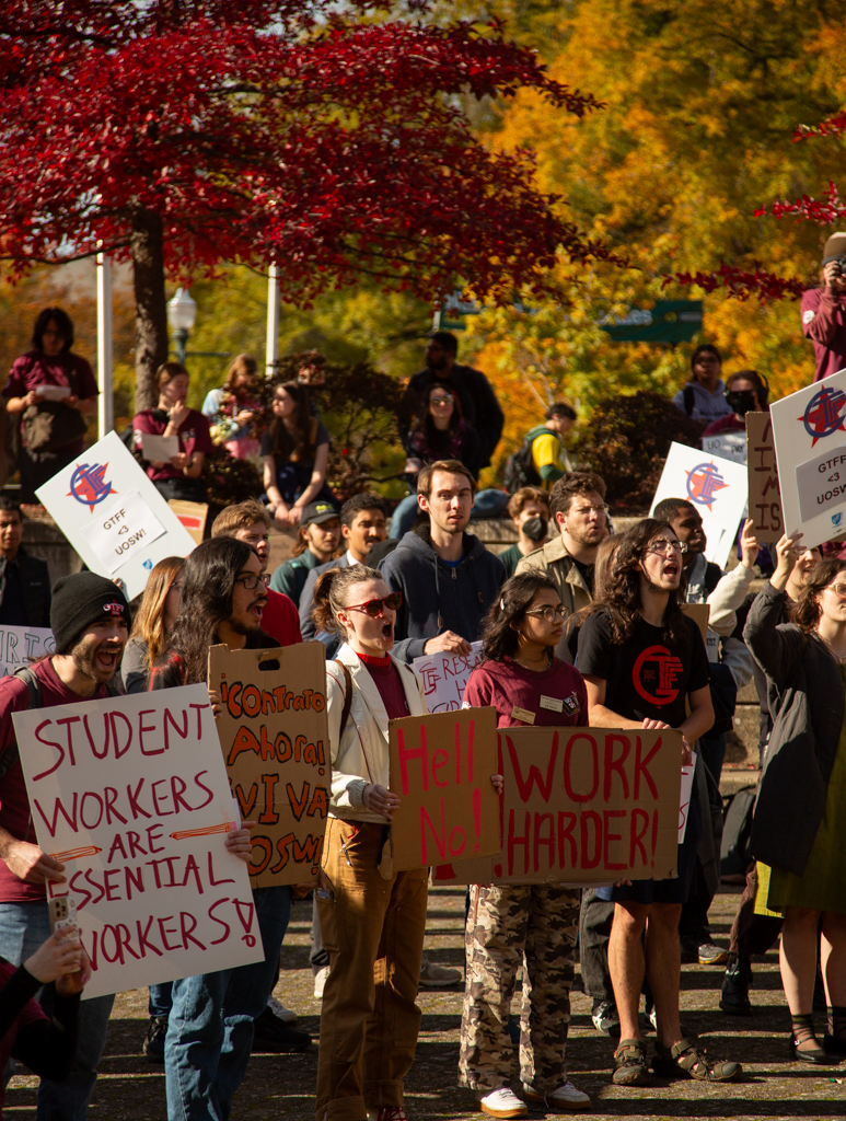 Members and supporters of the union proudly holding up their signs. On Oct. 25, 2024 The University of Oregon Student Workers Union rallied outside the Erb Memorial Union to show that the university is “failing on fundamental principles.” (Roshni Ram/Emerald)