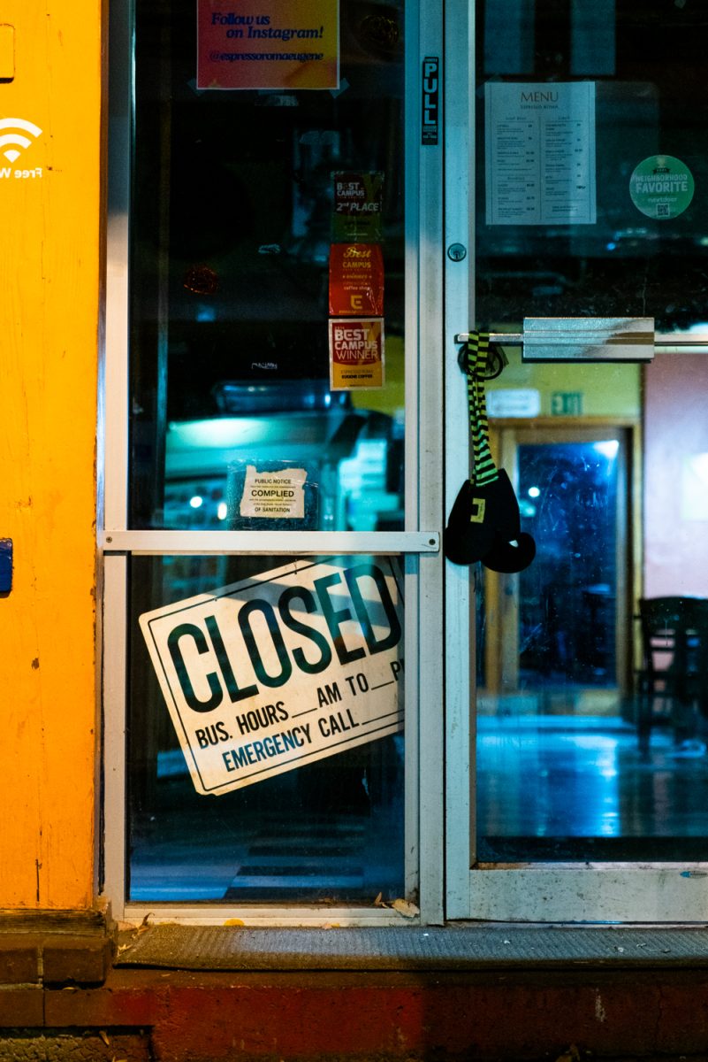 A closed sign hangs in the doorway of Eugene business at night. (Rowan Campbell/Emerald)