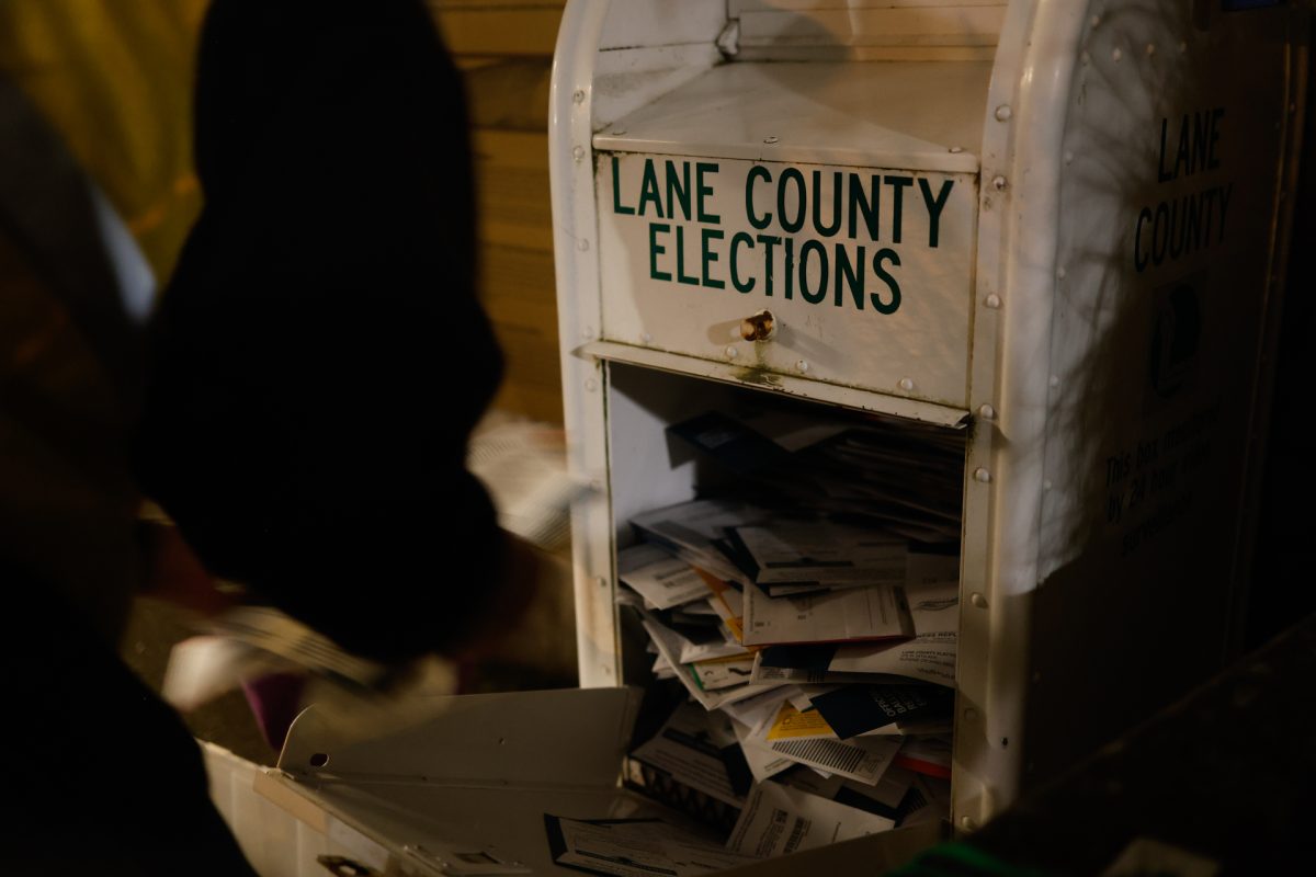 Dennis Larson and Alan Laemmer, extra help workers with Lane County Elections, attend the ballot box outside of the Erb Memorial Union on Nov. 5, 2024. Voters were able to cast their ballot any time before 8 p.m. on election night before ballots were delivered to be counted. (Alex Hernandez/Emerald)