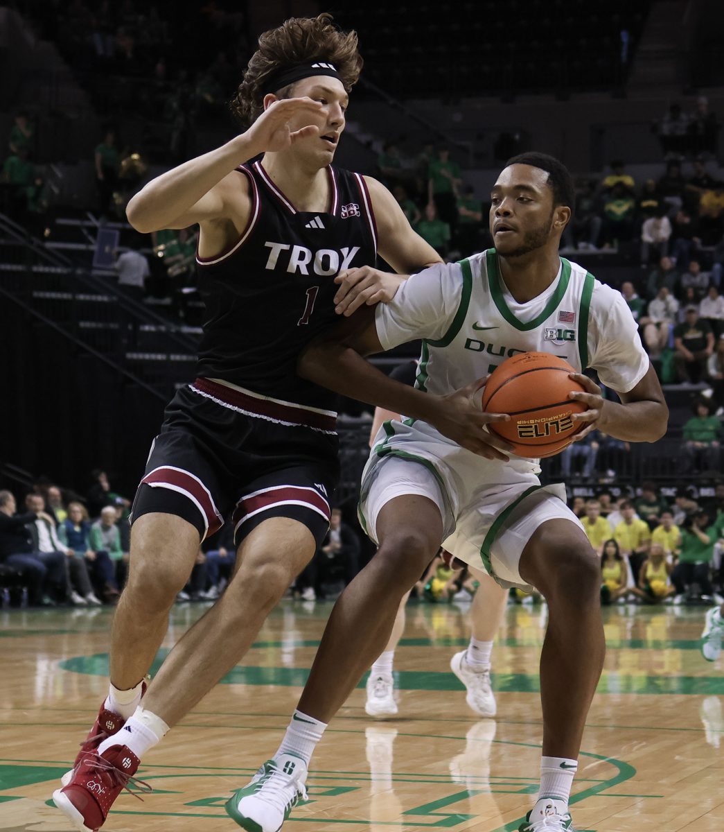 Oregon forward Kwame Evans Jr. (10) tries to get around Troy forward Thomas Dowd (1). The University of Oregon Ducks defeated the Troy University Trojans 82-61 on Sunday, November 17. Now 4-0 in the season, the Ducks will play the Oregon State Beavers on November 21. (Miles Cull/Emerald)