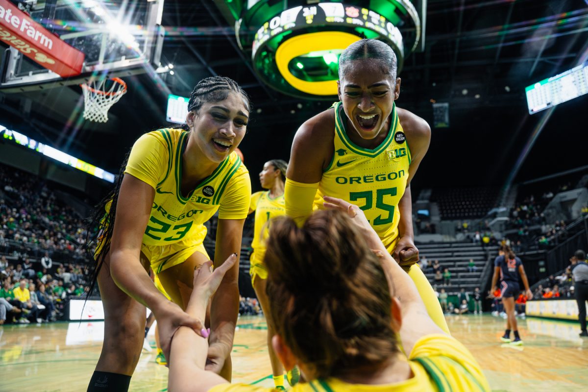 Sarah Rambus (25) and Deja Kelly celebrate while helping up teammate Elisa Mevius (8). The Oregon Ducks women's basketball team takes on the Auburn Tigers on Nov. 20, 2024, at Matthew Knight Arena in Eugene, Ore. (Jordan Martin/Emerald)