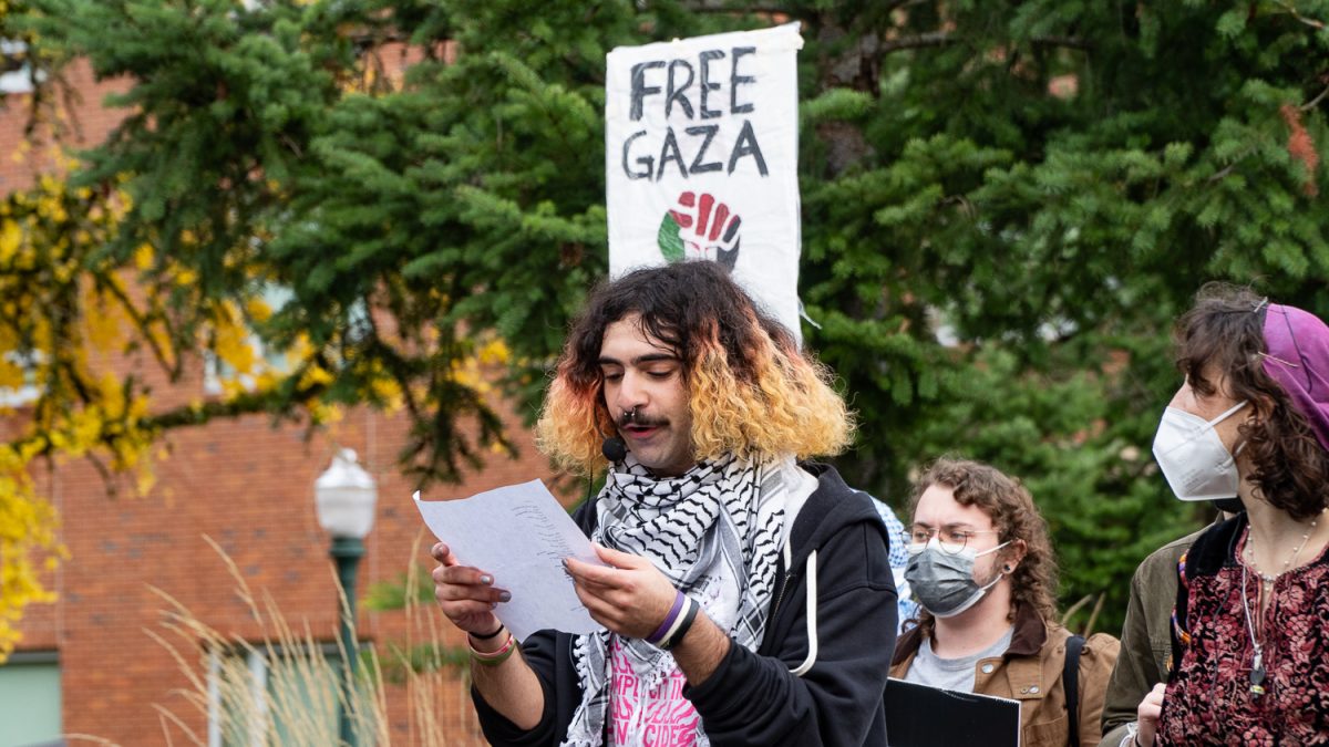 Salem Younes, an organizer of the rally, reading chants off a script as crowd marches through campus. (Saj Sundaram/Emerald)