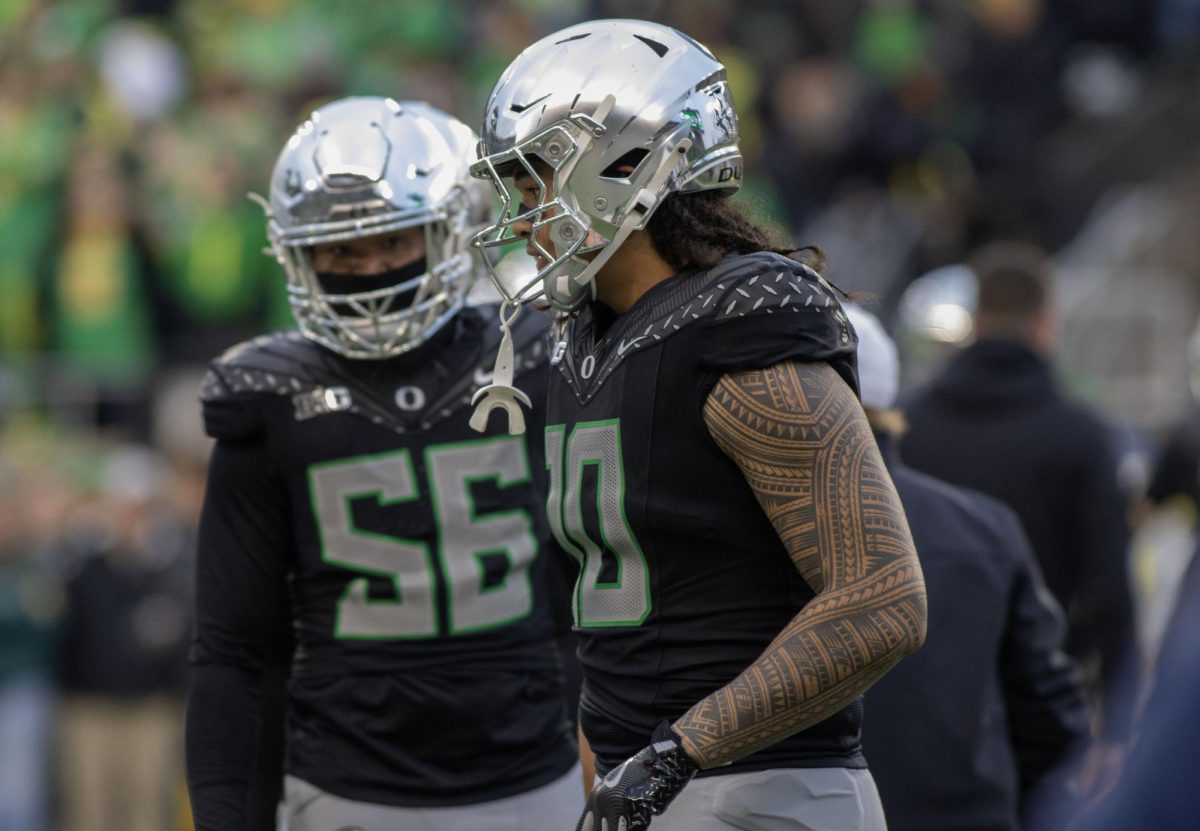 Matayo Uiagalelei (10) and Jaeden Moore (56) warmup before taking on the Washington Huskies. No. 1 Oregon defeats Washington 49-21 for an undefeated regular season at Autzen Stadium on Nov. 30, 2024. (Alyssa Garcia/Emerald) 

